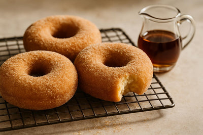 Doughnuts finished with maple sugar dusting on a cooling rack