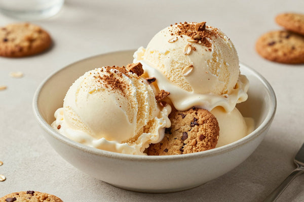 Two generous scoops of oatmeal cookie ice cream in a shallow ceramic bowl, softly melting at the edges