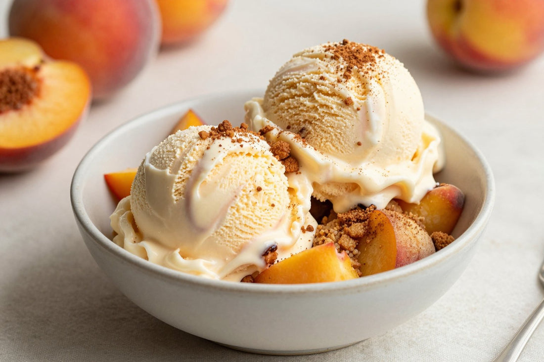 Two generous scoops of peach cobbler ice cream in a shallow ceramic bowl, softly melting at the edges