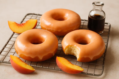 Doughnuts finished with peach glaze on a cooling rack