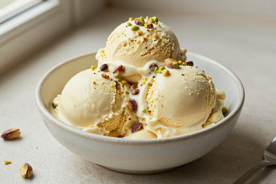 Two generous scoops of pistachio ice cream in a shallow ceramic bowl, softly melting at the edges