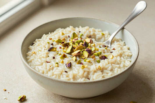 Creamy pistachio rice pudding in a small ceramic bowl with a spoon, garnished as in the recipe