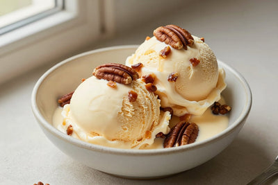Two generous scoops of praline ice cream in a shallow ceramic bowl, softly melting at the edges