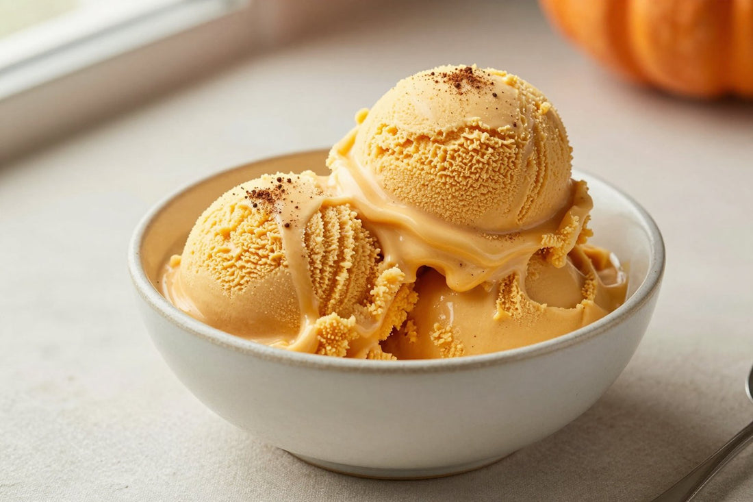 Two generous scoops of pumpkin pie ice cream in a shallow ceramic bowl, softly melting at the edges