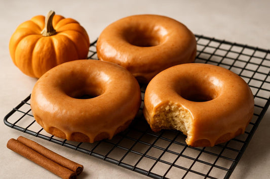 Doughnuts finished with pumpkin spice glaze on a cooling rack