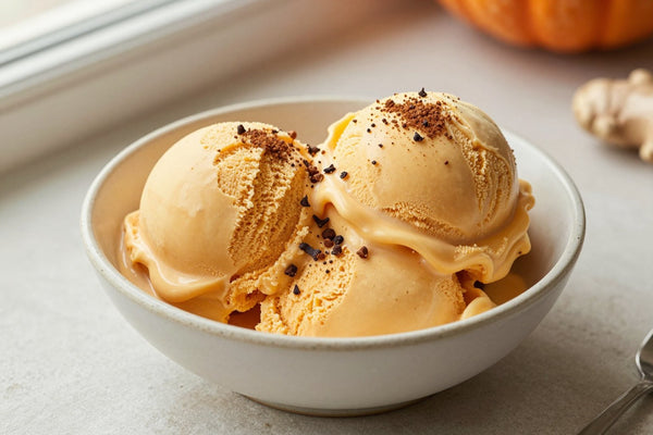 Two generous scoops of pumpkin spice ice cream in a shallow ceramic bowl, softly melting at the edges