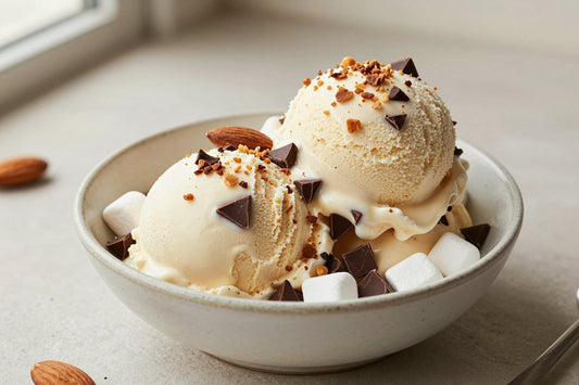 Two generous scoops of rocky road ice cream in a shallow ceramic bowl, softly melting at the edges