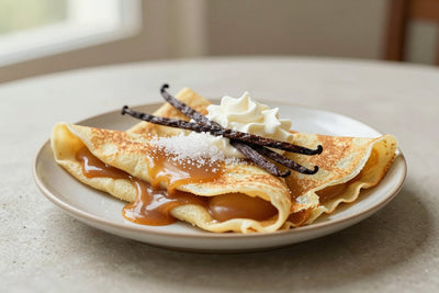 Folded salted caramel crêpes on a plate, the filling and toppings from the recipe clearly visible
