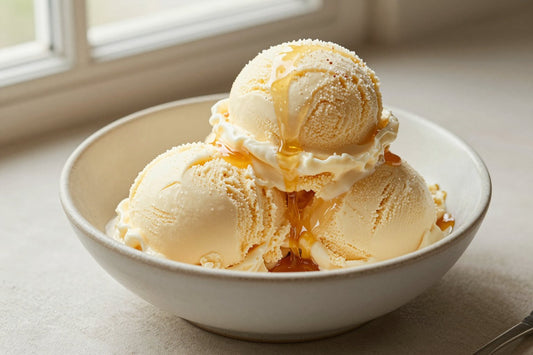Two generous scoops of salted honey ice cream in a shallow ceramic bowl, softly melting at the edges