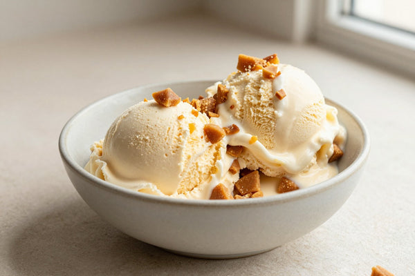 Two generous scoops of toffee ice cream in a shallow ceramic bowl, softly melting at the edges