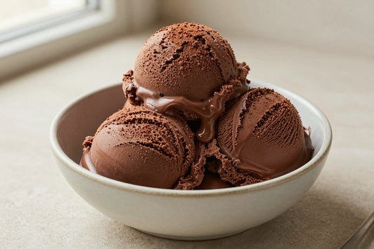 Two generous scoops of triple chocolate ice cream in a shallow ceramic bowl, softly melting at the edges