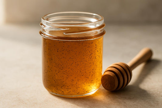 Jar of vanilla bean honey with a honey dipper