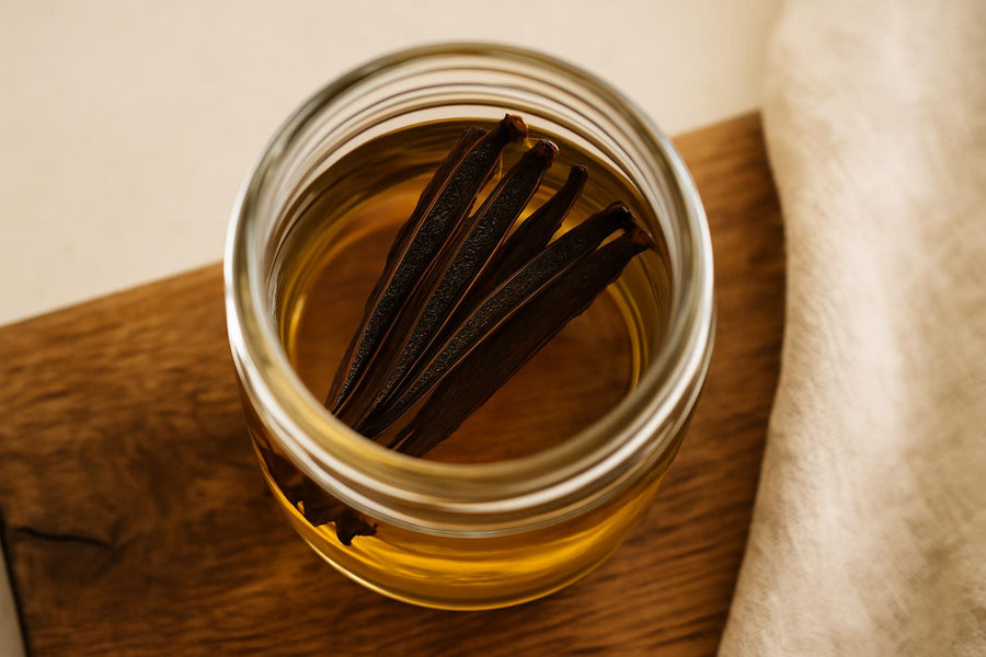 Split vanilla beans steeping in vodka in a glass jar for homemade vanilla extract