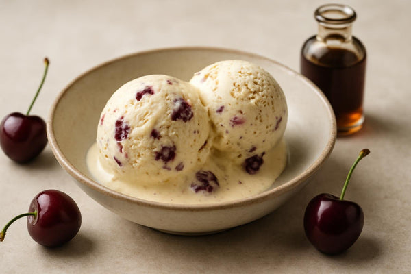Scoops of vanilla cherry cardamom custard ice cream in a ceramic bowl