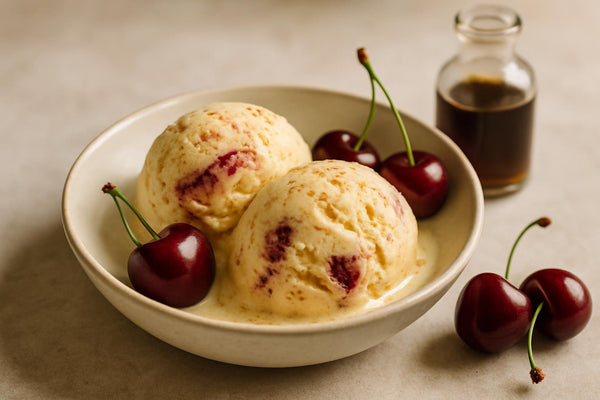 Scoops of vanilla cherry cinnamon custard ice cream in a ceramic bowl