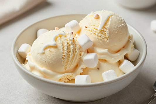 Two generous scoops of vanilla marshmallow ice cream in a shallow ceramic bowl, softly melting at the edges
