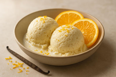 Scoops of vanilla orange cardamom custard ice cream in a ceramic bowl