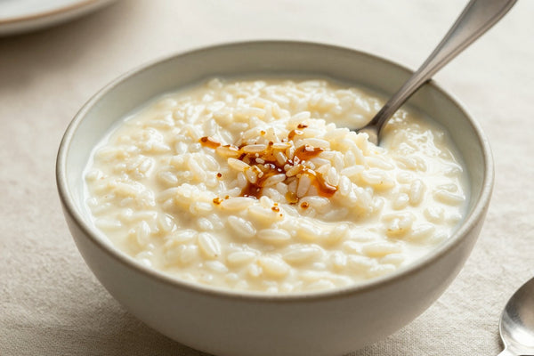 Creamy vanilla rice pudding in a small ceramic bowl with a spoon, garnished as in the recipe