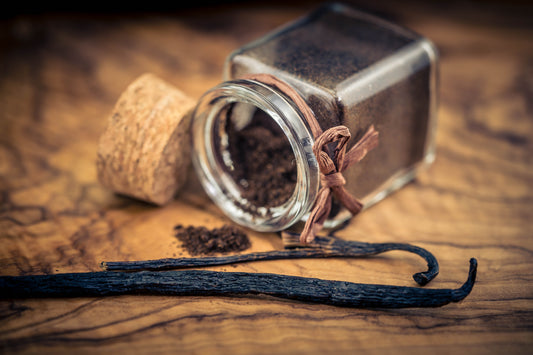 Dark ground vanilla bean powder next to lighter commercial vanilla powder showing texture and color differences