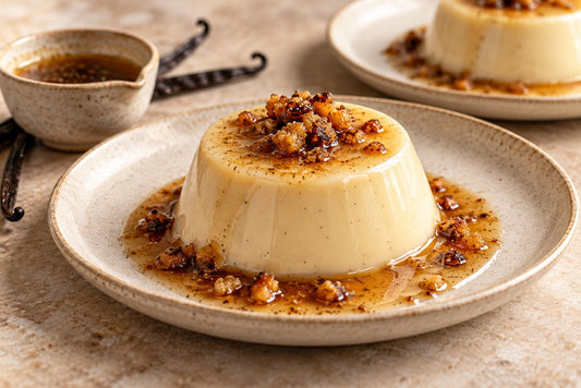 Vegan Brown Butter Vanilla Panna Cotta, unmolded on a plate with vanilla beans