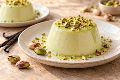 Vegan Pistachio Vanilla Panna Cotta, unmolded on a plate with vanilla beans